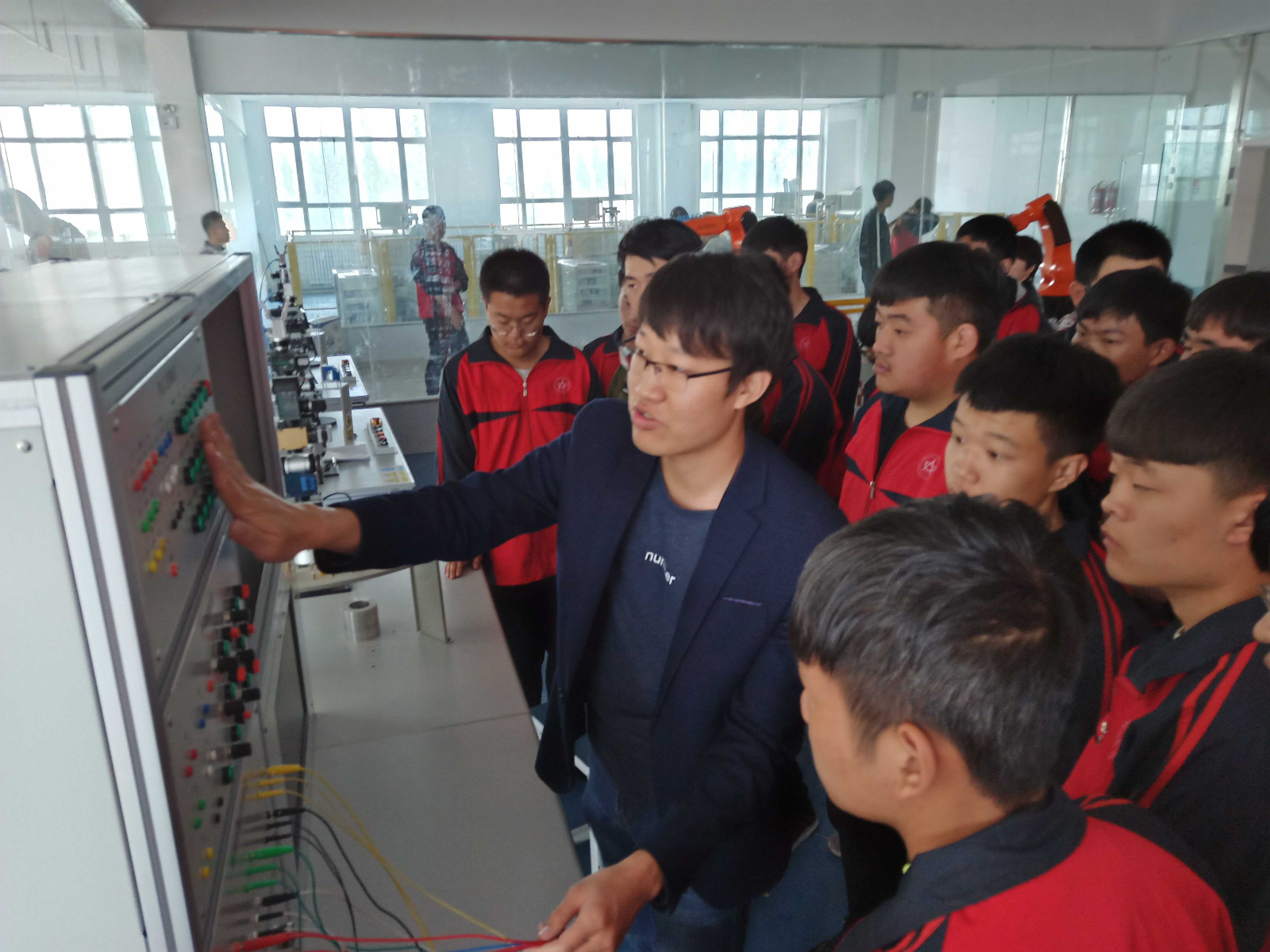 1558413256307050.jpg 教师给学生讲解机械手使用时电路控制原理.jpg